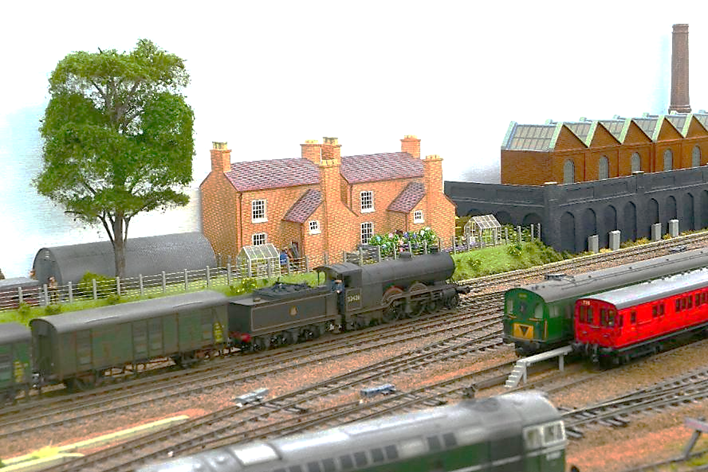 A model train set with a house and trees

AI-generated content may be incorrect.