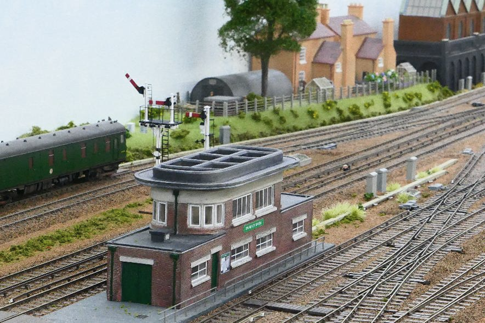 The rear of Ewhurst Green’s Art Deco Type 13 signal box. All the doors have been repainted and a notice board added outside the entry-door opposite where a staff foot-crossing will be sited into the Up side yard. 
The window frames still need to be repainted brown.
www.EwhurstGreen.com 
