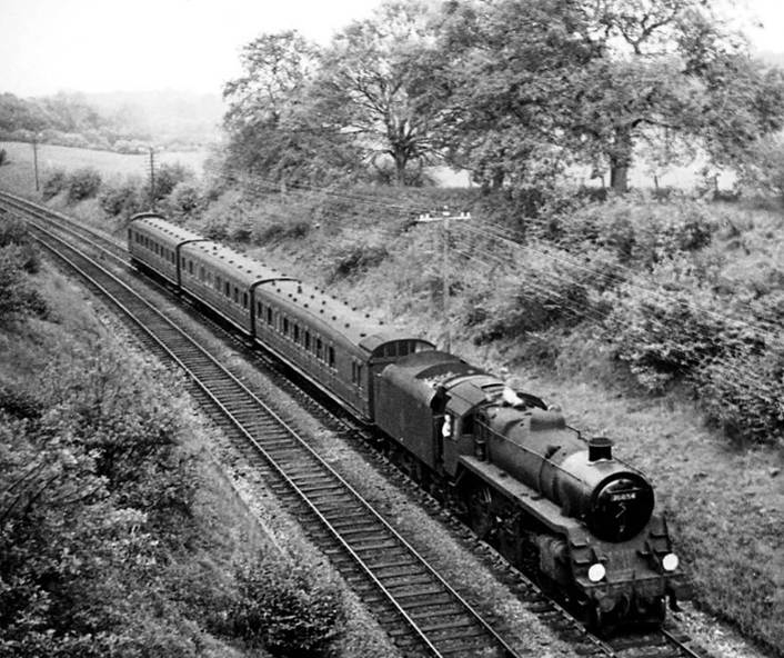 From White Down Lane overbridge, an unidentified Birdcage trio approaches Gomshall & Shere on the 5.31pm Redhill to Reading South train (1st June 1957) hauled by BR Standard 4MT no. 76054.
Ben Brooksbank (Geograph/CC-by-SA)