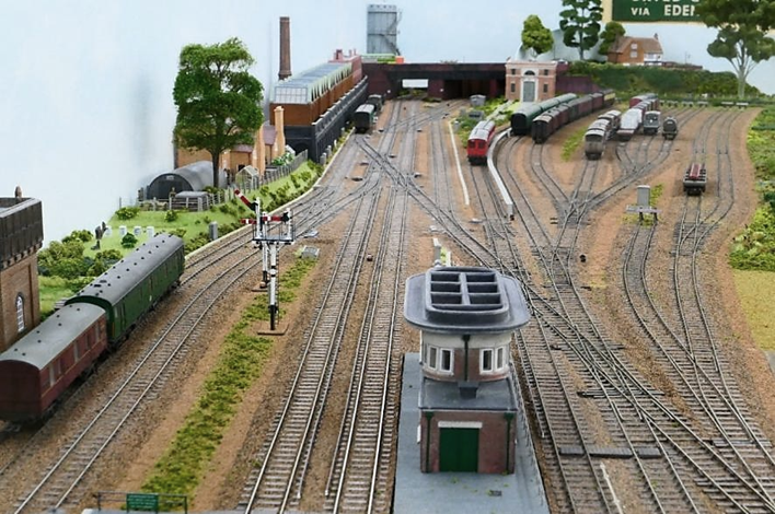 Looking south towards the double junction and the line to Cranleigh (curves away just to the left of and behind the sub-station) from above the Up Main Line platform. 
The correct six-foot dimension between Up and Down Main lines is noticeable in this photograph as is the correct conductor rail offset whilst allowing for the 16.5mm gauge track. 
www.EwhurstGreen.com 
